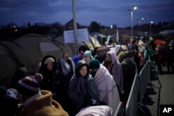 Refugees fleeing Russia's invasion of Ukraine queue at the Medyka border crossing, Poland, March 10, 2022. (AP Photo/Daniel Cole, File)