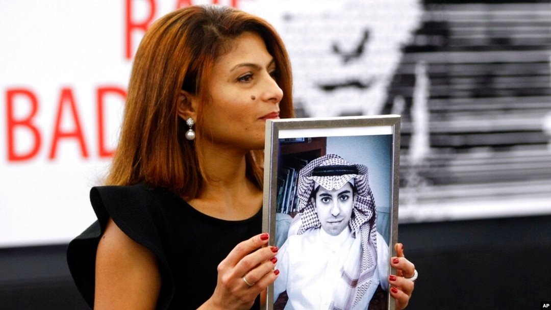 FILE - Ensaf Haidar, wife of Saudi blogger Raif Badawi, shows a portrait of him as he is awarded the Sakharov Prize in Strasbourg, France, Dec. 16, 2015. Badawi was released March 11, 2021, after a decade in prison for criticizing the Saudi conservative religious establishment.