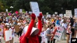 FILE - In this Oct. 2, 2021, photo, Cindy Gomez of Austin attends the Women's March ATX rally, at the Texas State Capitol in Austin, Texas.