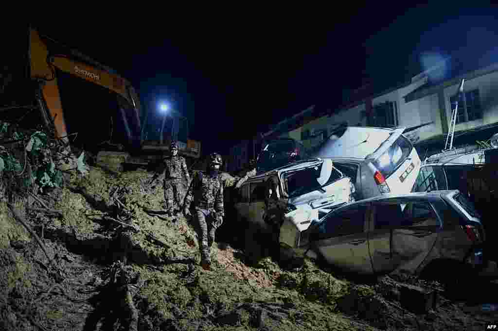 Rescue workers search for victims after a landslide was triggered by heavy rains in the township of Ampang, outside Kuala Lumpur.