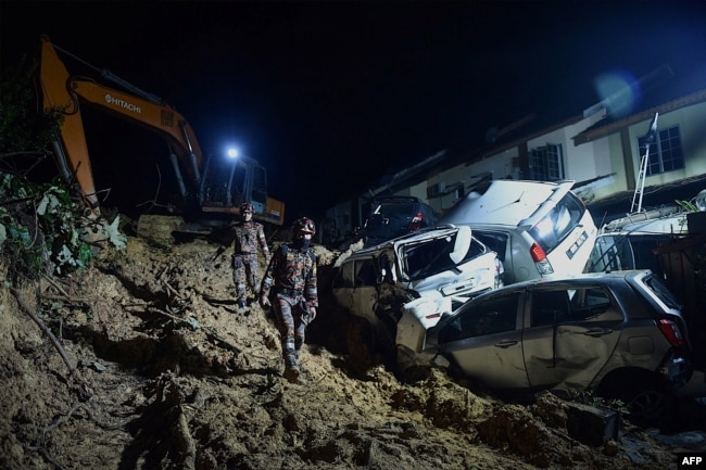 Rescue workers search for victims after a landslide caused by heavy rains in the township of Ampang, outside Kuala Lumpur. (Photo by Arif Kartono / AFP)