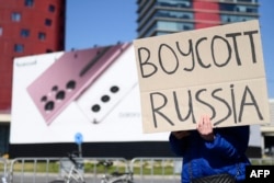 FILE - A pro-Ukraine demonstrator protests against Russia outside the venue of the MWC (Mobile World Congress) in Barcelona, March 1, 2022.