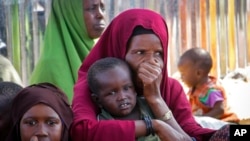 FILE - Somalis who fled drought-stricken areas of their country sit at a makeshift camp on the outskirts of the capital, Mogadishu, Feb. 4, 2022. Thousands of desperate families have fled a severe drought across large parts of Somalia.