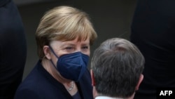 FILE - Former German Chancellor Angela Merkel talks with the former leader of Germany's Christian Democratic Union (CDU) Armin Laschet in Berlin on Feb. 13, 2022.