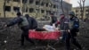 یک زن باردار مجروح که پس از بمباران زایشگاهی در شهر محاصره شده ماریوپل توسط امدادگران حمل می‌شود - ۱۸ اسفند ۱۴۰۰