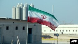 Bendera Iran berkibar di depan pembangkit listrik nuklir Bushehr dalam upacara peresmian pengoperasian reactor kedua di pembangkit tersebut, 10 November 2019. (Foto: Atta Kenare/AFP)