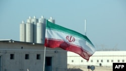 Bendera Iran di pembangkit listrik tenaga nuklir Bushehr Iran, saat peresmian dimulainya pekerjaan pembangunan reaktor kedua di fasilitas tersebut. (Foto: AFP)