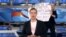 A protester is seen behind an anchorwoman on Russian state TV Channel One, March 14, 2022, in his screen grab taken from YouTube.