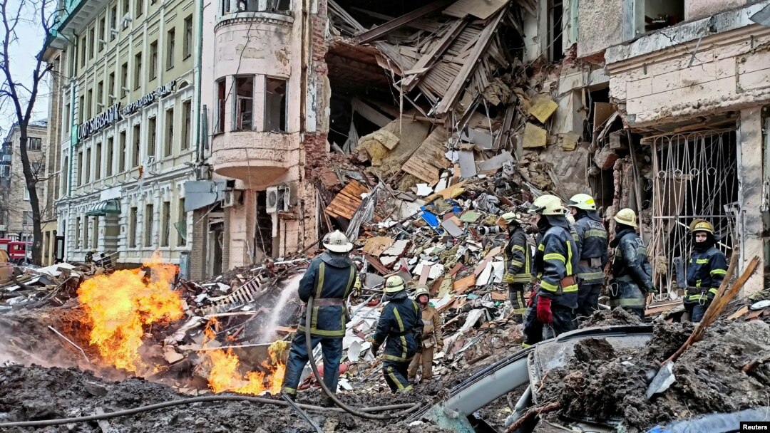 Rescuers work next to a building damaged by air strike, as Russia's attack on Ukraine continues, in central Kharkiv, Ukraine, March 14, 2022.
