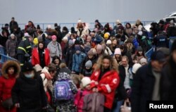 People arrive by ferry after fleeing from Russia's invasion of Ukraine, at the Isaccea-Orlivka border crossing, Romania, March 14, 2022.