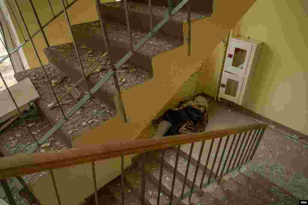 基辅北郊伊尔平，为防流浪狗，一具男性的尸体被移到了一栋受损的建筑内。（2022年3月13日）