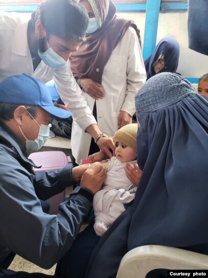 Perwakilan WHO di Afghanistan Dr Luo Dapeng bergabung dengan kampanye vaksinasi campak dan memvaksinasi seorang anak di Provinsi Wardak pada 13 Maret 2022. (Courtesy photo/WHO)