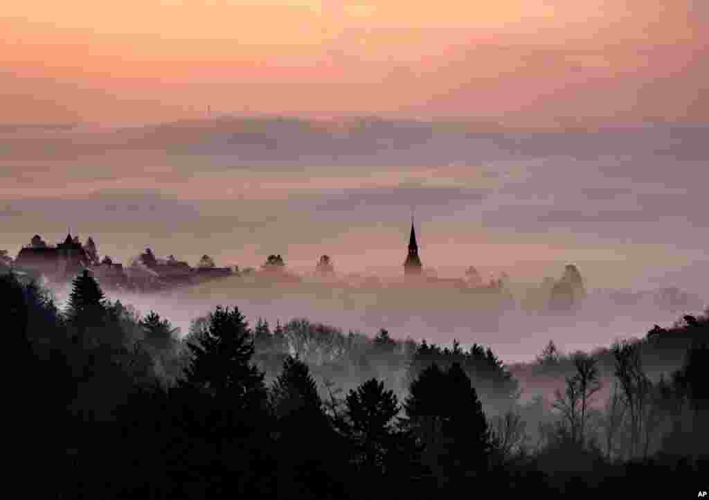 Fog crawls up to the city of Kronberg, near Frankfurt, Germany.