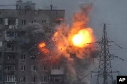 An explosion in an apartment building that came under fire from a Russian army tank in Mariupol, Ukraine, March 11, 2022.