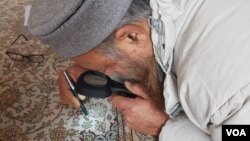 Inspecting a hand-knotted Kashmiri carpet at IICT Srinagar. (Bilal Hussain/VOA)