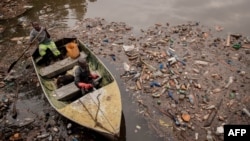 Des ouvriers de la centrale hydroélectrique de Ruzizi I effectuent une tournée d'inspection de la rivière Ruzizi pour voir le niveau de déchets plastiques autour du barrage, Bukavu, RDC, 17 mars 2022 (AFP).