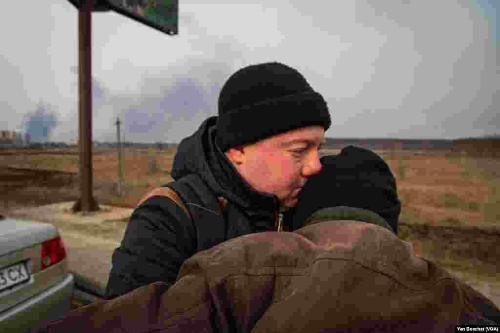 A man helps his grandfather after fleeing the town of Irpin, where Russian and Ukrainian troops had been fighting for days. Irpin, Ukraine, March 12, 2022. (Yan Boechat/VOA)