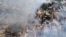 File - Smoke arises from burning buildings in Waraisuplia village in Kayah State, Myanmar where Myanmar’s military is targeting civilians in air and ground attacks, Feb. 18, 2022.