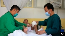 FILE - An Afghan boy receives medical care at the International Committee of the Red Cross physical rehabilitation center after being injured in fighting between the Taliban and Afghan security personnel, in Kabul, Afghanistan, Aug. 10, 2021.