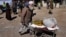 FILE - An Afghan man carries food supplies in a wheelbarrow during a distribution of humanitarian aid for families in need, in Kabul, Afghanistan, Feb. 16, 2022. 