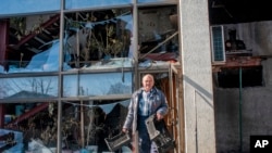A man walks next to an apartments building hit by shelling in Kharkiv, Ukraine, March 20, 2022.