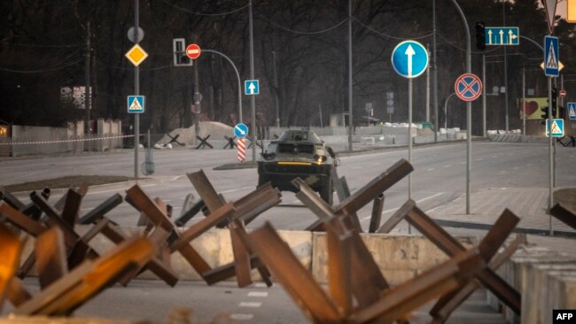 Un vehículo blindado de las Fuerzas Armadas de Ucrania conduce detrás de las barricadas a lo largo de una calle en la capital de Ucrania, Kiev, el 19 de marzo de 2022.