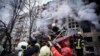 Des pompiers ukrainiens évacuent un homme d'un immeuble touché par un bombardement à Kiev, en Ukraine, le lundi 14 mars 2022, lors du conflit entre la Russie et l'Ukraine. (Photo AP/Service d'urgence de l'État ukrainien)