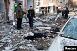 A body of a person is seen on ground near a building destroyed by shelling as Russia's attack on Ukraine continues, in Kyiv, Ukraine, March 14, 2022.