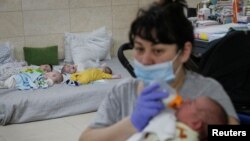 Nurse Oksana Martynenko looks after surrogate born babies inside a special shelter owned by BioTexCom clinic in a residential basement, on the outskirts of Kyiv, Ukraine, March 15, 2022.