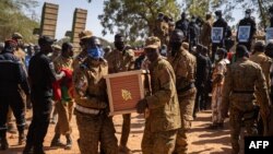 Des militaires burkinabè portent un cercueil d'un soldat, mort lors de l'attaque d'un camp de gendarmerie à Inata. (archives)