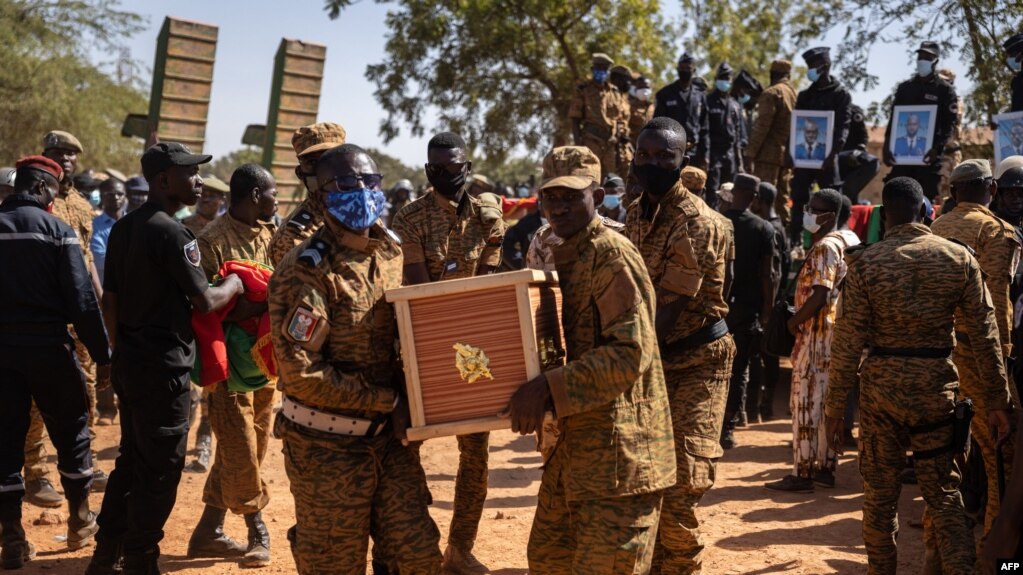 Des militaires burkinabè portent un cercueil d'un soldat dans la section militaire du cimetière de Gounghin à Ouagadougou le 23 novembre 2021, après la mort dudit soldat lors de l'attaque d'un camp de gendarmerie à Inata au Burkina Faso le 14 novembre 202