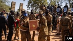 Des militaires burkinabè portent un cercueil d'un soldat dans la section militaire du cimetière de Gounghin à Ouagadougou le 23 novembre 2021, après la mort dudit soldat lors de l'attaque d'un camp de gendarmerie à Inata au Burkina Faso le 14 novembre 202