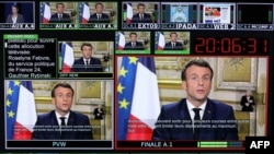 FILE - This photograph taken March 12, 2020, shows screens displaying France's President Emmanuel Macron giving a speech, at a France 24 TV studio, in Issy-Les-Moulineaux, near Paris.