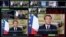 FILE - This photograph taken March 12, 2020, shows screens displaying France's President Emmanuel Macron giving a speech, at a France 24 TV studio, in Issy-Les-Moulineaux, near Paris.