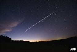 FILE - In this photo taken Feb. 7, 2021, a long-exposure image shows a trail of a group of SpaceX's Starlink satellites passing over Uruguay as seen from the countryside some 185 kilometers north of Montevideo.