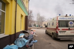 Bodies of people killed by shelling lay covered outside hospital number 3 in Mariupol, Ukraine, March 15, 2022.