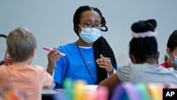 Kiara Beard works with children in a before- and afterschool program operated by the YMCA of Middle Tennessee in Wednesday, March 16, 2022, in Nashville, Tenn. 