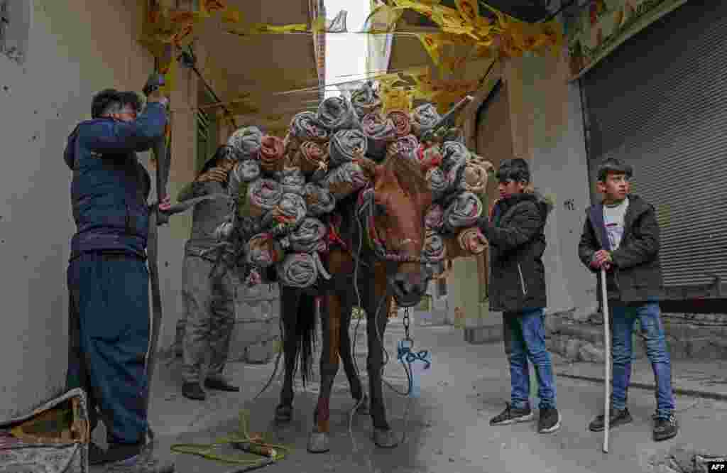 Men use a horse to transport torches during celebrations of the Persian new year Nowruz (Noruz) in the town of Akra, about 100 kilometers north of Arbil, in Iraq&#39;s northern autonomous Kurdish region.