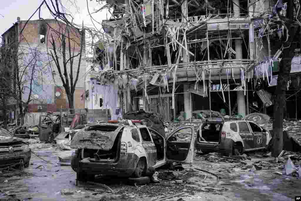 Damaged vehicles and other remains surround the destroyed Kharkiv city center in Ukraine, March 16, 2022.
