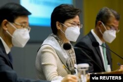 Kepala Sekretaris Hong Kong John Lee, Kepala Eksekutif Hong Kong Carrie Lam dan Sekretaris Keuangan Hong Kong Paul Chan menghadiri konferensi pers di Hong Kong, China, 21 Maret 2022. (Foto: via Reuters)