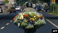 En la imagen de archivo un hombre conduce una motocicleta cargando bolsas de vegetales en la ciudad indígena de Izalco, 60 km al oeste de San Salvador.