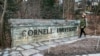 A woman walks by a Cornell University sign on the Ivy League school's campus in Ithaca, New York, Jan. 14, 2022. 