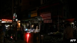 Street food vendors wait for customers during a power outage in Yangon, Myanmar, March 3, 2022. 
