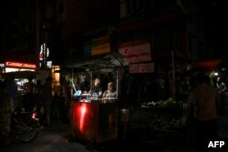 Street food vendors wait for customers during a power outage in Yangon, Myanmar, March 3, 2022.