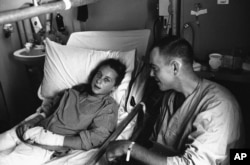 FILE - French photographer Catherine Leroy talks with Lt. Robert Brown on May 28, 1967, from hospital bed aboard hospital ships USS Sanctuary in South China Sea off the coast of Vietnam. Both were wounded by the same North Vietnamese mortar. (AP Photo)