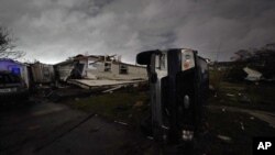 Una camioneta yace de costado frente a una casa destruida después de que un tornado arrasara el área en Arabi, Louisiana, el martes 22 de marzo de 2022. 
