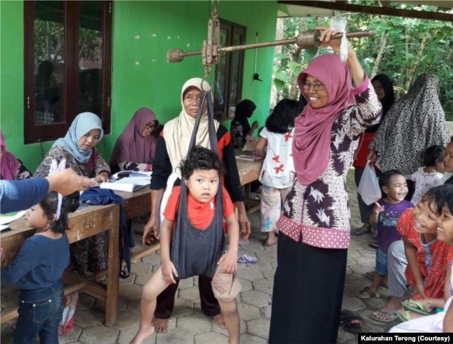 Seorang balita sedang ditimbang berat badan di Posyandu Padukuhan Terong II, Kalurahan Terong, Bantul, DIY. (Foto: Kalurahan Terong)