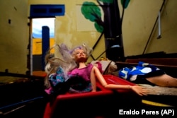 A Barbie doll lays in a classroom of an abandoned school in the Pinheiro neighborhood of Maceio, Alagoas state, Brazil, March 6, 2022. (AP Photo/Eraldo Peres)