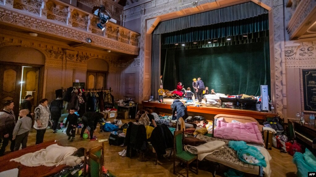 Refugiados ucranianos permanece en teatro de Ucrania, donde está instalado un refugio para en Przemysl, sureste de Polonia, cerca de la frontera entre Ucrania y Polonia, el 18 de marzo de 2022.