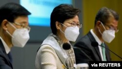 香港政務司司長李家超（左）、香港特首林鄭月娥（中）和香港財政司司長陳茂波（右）出席 2022 年 3 月 21 日在香港舉行的抗疫記者會。(路透社照片) 